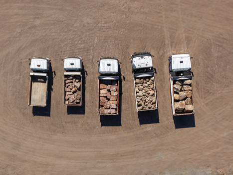 Kilsyth Australia 20 September 2026 Aerial view of five dump trucks parked in a row on a dirt lot with some vehicles loaded with large rocks and others empty. Kilsyth Australia 20 September 2026 Aerial view of five dump trucks parked in a row on a dirt lot with some vehicles loaded with large rocks and others empty.