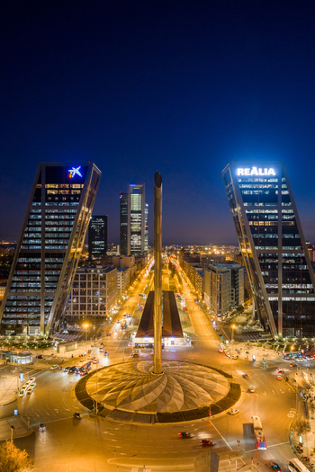 Aerial view of Plaza Castilla at night featuring the illuminated KIO Towers busy city traffic flowing through the roundabout and surrounding streets in Madrid Comunidad de Madrid Spain. Aerial view of Plaza Castilla at night featuring the illuminated KIO Towers busy city traffic flowing through the roundabout and surrounding streets in Madrid Comunidad de Madrid Spain.