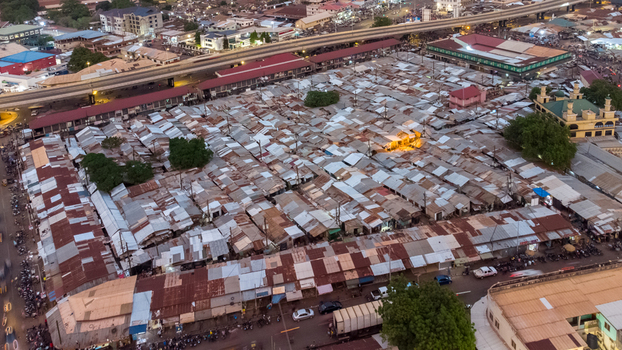 Aerial view of the bustling Tamale Central Market with its dense grid of corrugated metal roofs narrow alleyways and surrounding urban infrastructure in Tamale Northern Region Ghana. Aerial view of the bustling Tamale Central Market with its dense grid of corrugated metal roofs narrow alleyways and surrounding urban infrastructure in Tamale Northern Region Ghana.