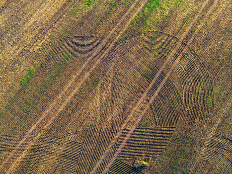 Aerial view of tractor tire tracks forming curved patterns on a harvested agricultural field in Taujenai Vilnius County Lithuania.