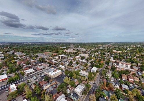 Aerial view of the urban landscape featuring residential and commercial buildings tree lined streets and a cloudy sky in Denver Colorado United States. Aerial view of the urban landscape featuring residential and commercial buildings tree lined streets and a cloudy sky in Denver Colorado United States.