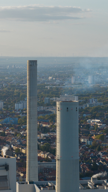 Aerial view of the Grosskraftwerk Mannheim power plant featuring two prominent industrial chimneys rising above the urban landscape of Mannheim Baden Wurttemberg Germany.