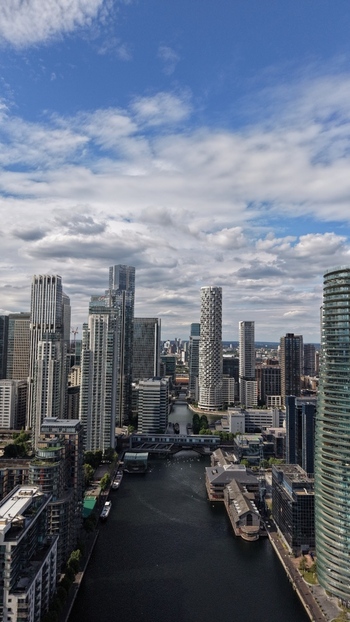 London United Kingdom 16 June 2026 Aerial view of Canary Wharf skyscrapers including One Park Drive and Newfoundland tower overlooking the South Dock waterway under a cloudy sky.