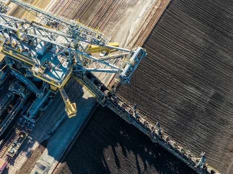 Aerial view of Tagebau Welzow Sud brown coal open pit mine with a large bucket wheel excavator operating on dark soil in Spremberg Brandenburg Germany. Aerial view of Tagebau Welzow Sud brown coal open pit mine with a large bucket wheel excavator operating on dark soil in Spremberg Brandenburg Germany.