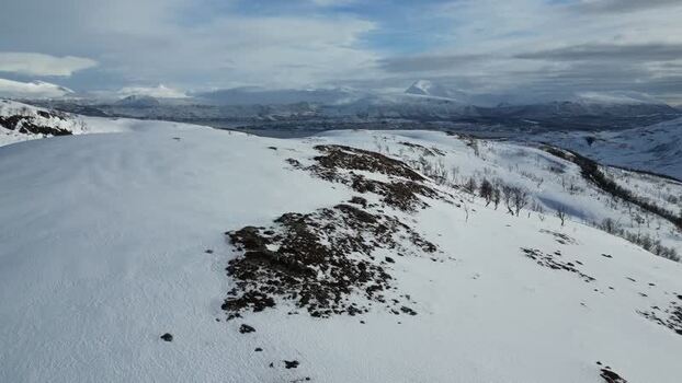 Aerial view of snowy Kvaloya mountain landscape Norway.