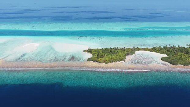 Aerial view of a tropical island and coral reefs Maldives.