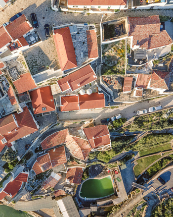 Aerial view of Azenhas do Mar from top view of the red rooftop of a small town along the wild Portuguese coastline Colares Portugal.