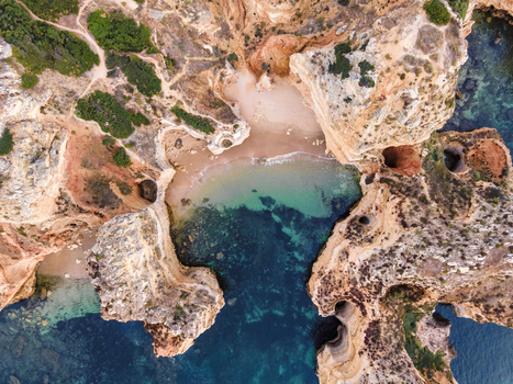 Aerial view of Praia dos Pinheiros a beautiful paradise beach along the coast with scenic cliffs near Ponta da Piedade Lagos Algarve region Portugal.