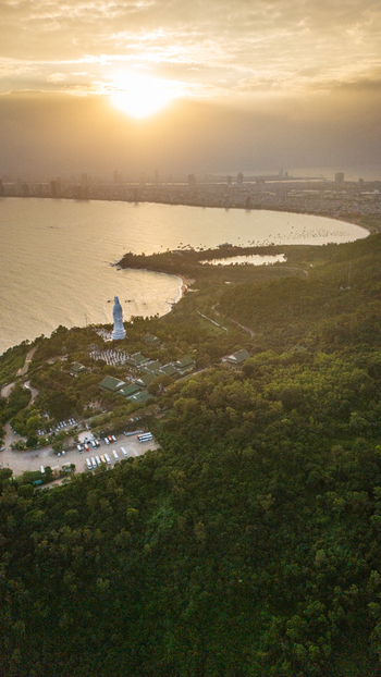 Aerial view of the Lady Buddha statue at Linh Ung Pagoda overlooking the coastline and city skyline of Da Nang Vietnam. Aerial view of the Lady Buddha statue at Linh Ung Pagoda overlooking the coastline and city skyline of Da Nang Vietnam.
