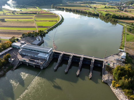 Aerial view of a hydroelectric dam and power station on a wide river surrounded by green fields and rolling hills Slovenia. Aerial view of a hydroelectric dam and power station on a wide river surrounded by green fields and rolling hills Slovenia.