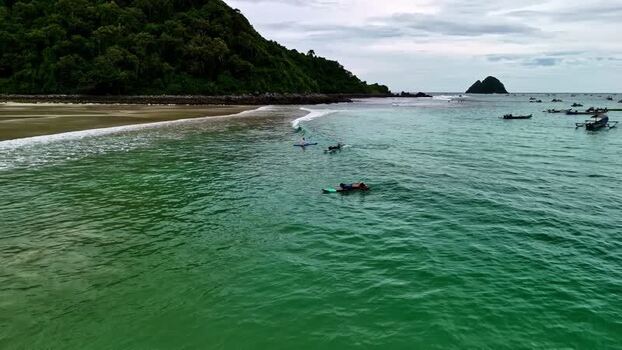 Aerial view of surfers in the ocean off the coast of Indonesia.