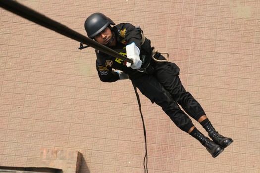 Dhaka Bangladesh 06 January 2017 View of a Rapid Action Battalion RAB member in black tactical gear and helmet rappelling down a rope at the RAB Headquarters. Dhaka Bangladesh 06 January 2017 View of a Rapid Action Battalion RAB member in black tactical gear and helmet rappelling down a rope at the RAB Headquarters.