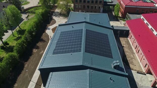 Aerial view of solar panels on a building roof in Latvia.