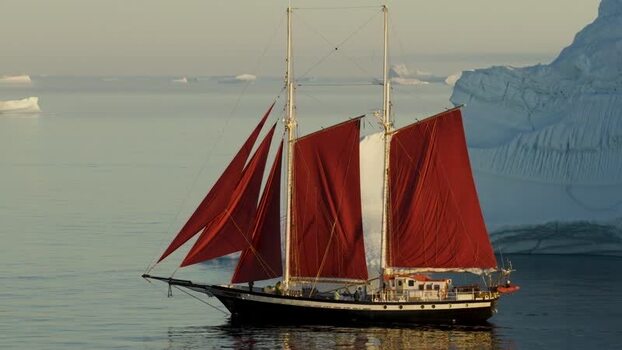 Aerial view of a sailboat with red sails in Greenland. Aerial view of a sailboat with red sails in Greenland.