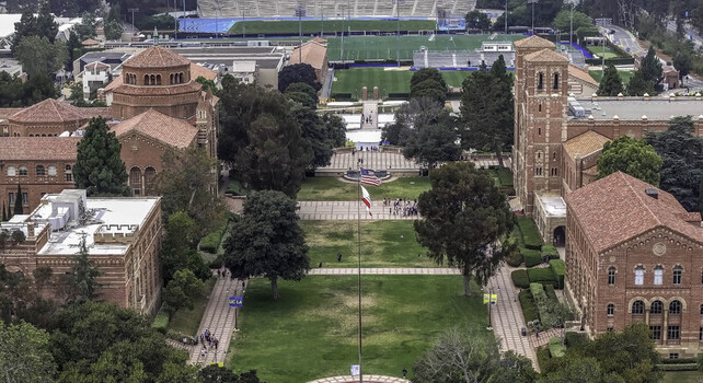 Aerial view of the UCLA campus in Westwood featuring historic red brick buildings lush green lawns walkways and trees under an overcast sky. Westwood California United States.