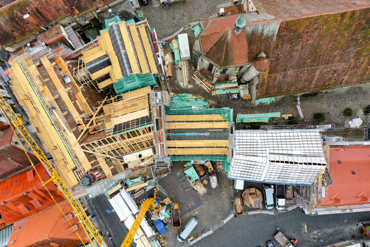 Aerial view of Rathaus Forchheim under renovation featuring extensive scaffolding wooden roof framing and a yellow construction crane Forchheim Bayern Germany. Aerial view of Rathaus Forchheim under renovation featuring extensive scaffolding wooden roof framing and a yellow construction crane Forchheim Bayern Germany.