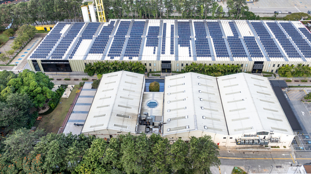 Aerial view of the Mercado Livre headquarters featuring a large rooftop solar power plant surrounded by trees and urban infrastructure in Osasco State of Sao Paulo Brazil.