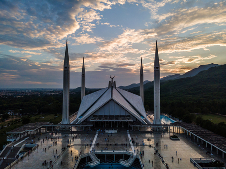 Aerial view of Faisal Masjid with its iconic four minarets and tent shaped architecture under a sunset sky with the Margalla Hills in the background Islamabad Islamabad Capital Ter Pakistan. Aerial view of Faisal Masjid with its iconic four minarets and tent shaped architecture under a sunset sky with the Margalla Hills in the background Islamabad Islamabad Capital Ter Pakistan.