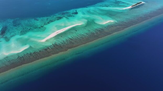 Aerial view of a long white sandbar and turquoise lagoon Maldives.