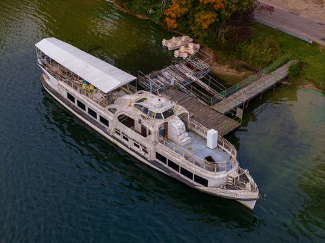 Aerial view of a large white excursion boat docked at a wooden pier on the calm waters of Lake Galve in Trakai Vilnius County Lithuania. Aerial view of a large white excursion boat docked at a wooden pier on the calm waters of Lake Galve in Trakai Vilnius County Lithuania.