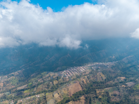 Aerial view of Wonokerto village nestled in the mountains of East Java featuring terraced fields and scattered houses in Sukorejo East Java Indonesia. Aerial view of Wonokerto village nestled in the mountains of East Java featuring terraced fields and scattered houses in Sukorejo East Java Indonesia.