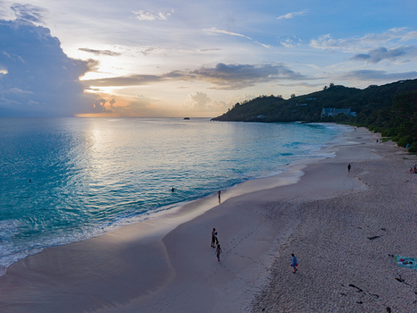 Aerial view of a serene beach with turquoise waters meeting the soft sandy shore under a pastel sky Quatre Bornes Mahe Island Seychelles. Aerial view of a serene beach with turquoise waters meeting the soft sandy shore under a pastel sky Quatre Bornes Mahe Island Seychelles.