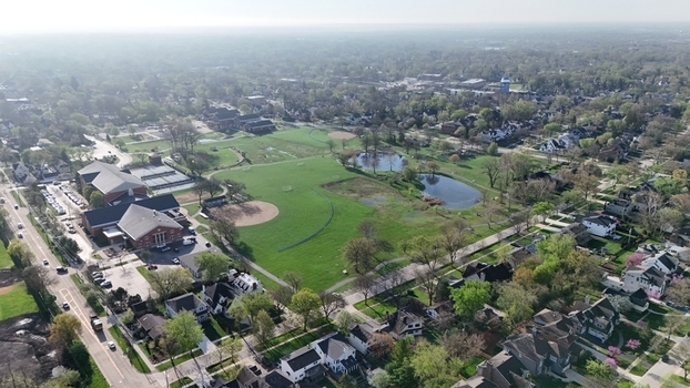 Aerial view of a suburban park with baseball diamonds green fields and small ponds surrounded by residential houses and trees in Chicago. Aerial view of a suburban park with baseball diamonds green fields and small ponds surrounded by residential houses and trees in Chicago.