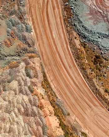 Aerial view of a large scale mining operation featuring a wide haul road with visible tire tracks excavated earth and piles of mine tailings in Thabazimbi Limpopo South Africa. Aerial view of a large scale mining operation featuring a wide haul road with visible tire tracks excavated earth and piles of mine tailings in Thabazimbi Limpopo South Africa.