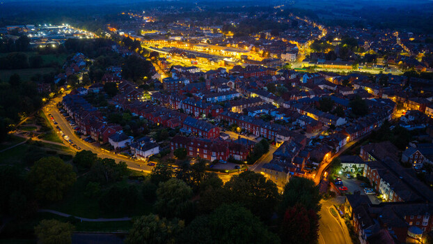Aerial view of the illuminated streets and residential rooftops of Salisbury at night showcasing the city lights and urban layout in Salisbury England United Kingdom. Aerial view of the illuminated streets and residential rooftops of Salisbury at night showcasing the city lights and urban layout in Salisbury England United Kingdom.