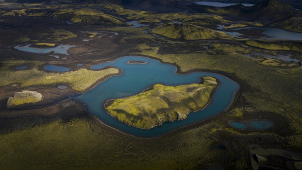 Aerial view of Langisjor lake with its turquoise waters surrounded by vibrant moss covered volcanic hills and rugged terrain Skaftarhreppur Iceland. Aerial view of Langisjor lake with its turquoise waters surrounded by vibrant moss covered volcanic hills and rugged terrain Skaftarhreppur Iceland.