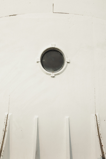 View of the porthole window on the white exterior wall of the historic Saxby Lighthouse in Saxby Laane maakond Estonia.