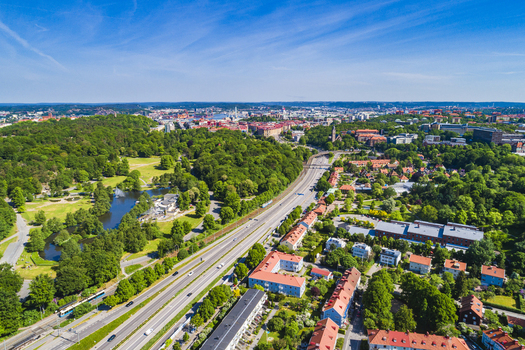 Aerial view of Slottsskogen park with its lush greenery and pond adjacent to a highway and residential neighborhood in Gothenburg Vastra Gotaland County Sweden.