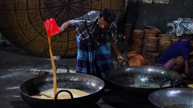 View of a man pouring milk into a large vat in Bogura Bangladesh. View of a man pouring milk into a large vat in Bogura Bangladesh.