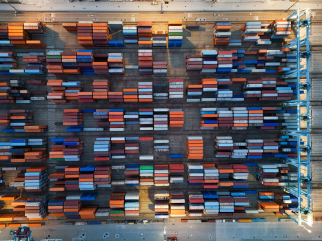 Aerial view of the semi automated container port showing rows of colorful shipping containers arranged in the storage yard with automated infrastructure in Vado Ligure Liguria Italy. Aerial view of the semi automated container port showing rows of colorful shipping containers arranged in the storage yard with automated infrastructure in Vado Ligure Liguria Italy.