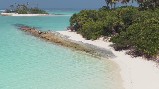 Aerial view of a tropical island and turquoise water Maldives.