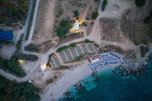 Aerial view of the Riserva Naturale Orientata dello Zingaro with sun loungers on the beach a restaurant area and turquoise water in San Vito Lo Capo Sicilia Italy. Aerial view of the Riserva Naturale Orientata dello Zingaro with sun loungers on the beach a restaurant area and turquoise water in San Vito Lo Capo Sicilia Italy.