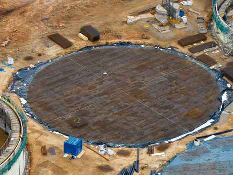 Aerial view of a large circular construction foundation with a steel rebar grid a blue storage container and surrounding earthworks in Lithuania. Aerial view of a large circular construction foundation with a steel rebar grid a blue storage container and surrounding earthworks in Lithuania.