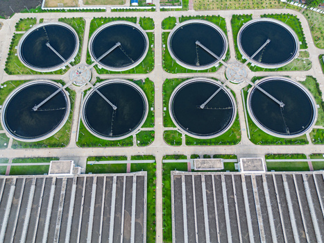 Aerial view of the Sewage Treatment Plant Dhaka WASA featuring circular clarifier tanks with rotating arms and green lawns in Dhaka Dhaka Division Bangladesh. Aerial view of the Sewage Treatment Plant Dhaka WASA featuring circular clarifier tanks with rotating arms and green lawns in Dhaka Dhaka Division Bangladesh.