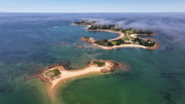 Aerial view of the serene &Icirc;le Callot under a blanket of low clouds kissed by the sun s golden light Carantec Brittany France.