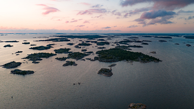 Aerial view of the rocky islands of Oro Fortress Island surrounded by the calm Baltic Sea during a soft sunset in Oro Varsinais Suomi Finland. Aerial view of the rocky islands of Oro Fortress Island surrounded by the calm Baltic Sea during a soft sunset in Oro Varsinais Suomi Finland.