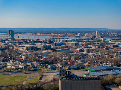 Aerial view of the urban skyline and bridges spanning the Ohio River under a clear blue sky in Louisville Kentucky United States. Aerial view of the urban skyline and bridges spanning the Ohio River under a clear blue sky in Louisville Kentucky United States.