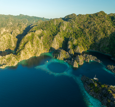 Aerial view of Twin Lagoon featuring turquoise waters limestone cliffs and lush vegetation in Coron Mimaropa Philippines. Aerial view of Twin Lagoon featuring turquoise waters limestone cliffs and lush vegetation in Coron Mimaropa Philippines.
