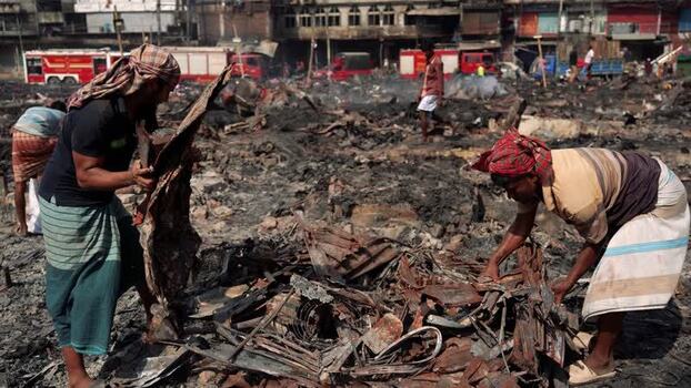 View of people sorting through fire debris in Dhaka Bangladesh. View of people sorting through fire debris in Dhaka Bangladesh.