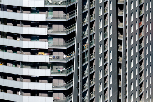 Aerial view of modern residential real estate featuring high rise apartment buildings with balconies and geometric facades in Katowice Silesian Voivodeship Poland.