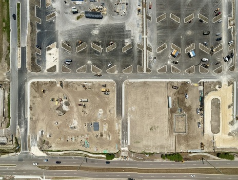 Aerial view of the construction site at Foundry Lane featuring a new parking lot layout heavy machinery and dirt ground in World Golf Village Florida United States.
