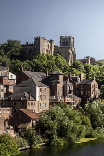 View of Durham Cathedral and historic stone buildings overlooking the River Wear on a sunny day in Durham England United Kingdom. View of Durham Cathedral and historic stone buildings overlooking the River Wear on a sunny day in Durham England United Kingdom.