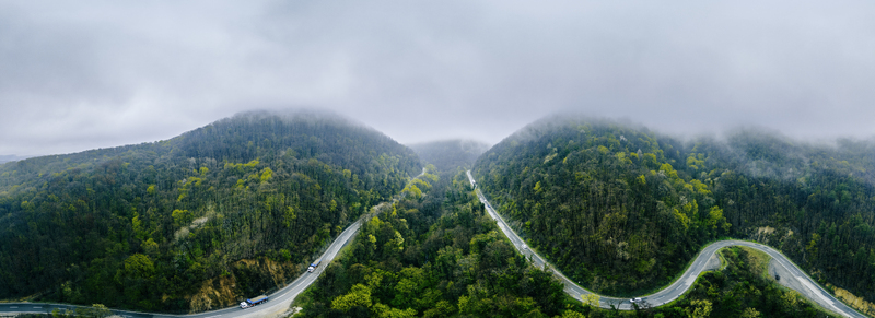 Aerial view of winding roads slicing through verdant hills shrouded in mist under a cloudy sky Novi Sad Vojvodina Serbia. Aerial view of winding roads slicing through verdant hills shrouded in mist under a cloudy sky Novi Sad Vojvodina Serbia.