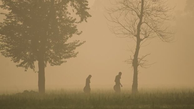 View of men walking in a foggy field Bangladesh. View of men walking in a foggy field Bangladesh.