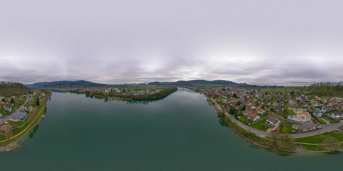 Aerial view of the Rhine River flowing through the town of Bad Sackingen with residential houses and green hills under an overcast sky in Bad Sackingen Baden Wurttemberg Germany. Aerial view of the Rhine River flowing through the town of Bad Sackingen with residential houses and green hills under an overcast sky in Bad Sackingen Baden Wurttemberg Germany.