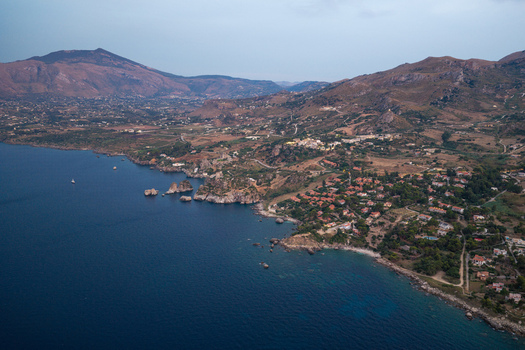 Aerial view of Riserva Naturale Orientata dello Zingaro featuring rugged coastal cliffs Mediterranean vegetation and blue sea waters in San Vito Lo Capo Sicilia Italy. Aerial view of Riserva Naturale Orientata dello Zingaro featuring rugged coastal cliffs Mediterranean vegetation and blue sea waters in San Vito Lo Capo Sicilia Italy.